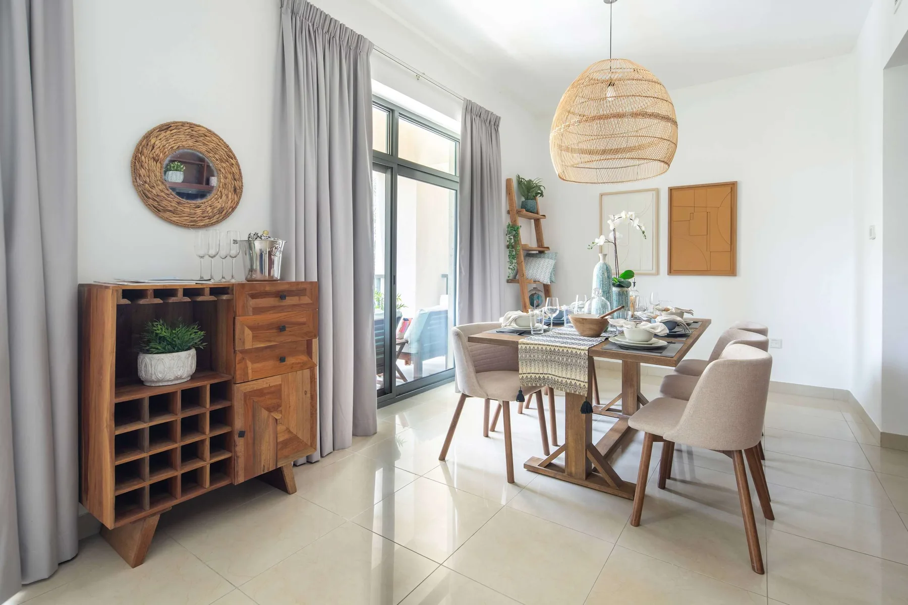A bright dining area with a wooden table set beside large windows.