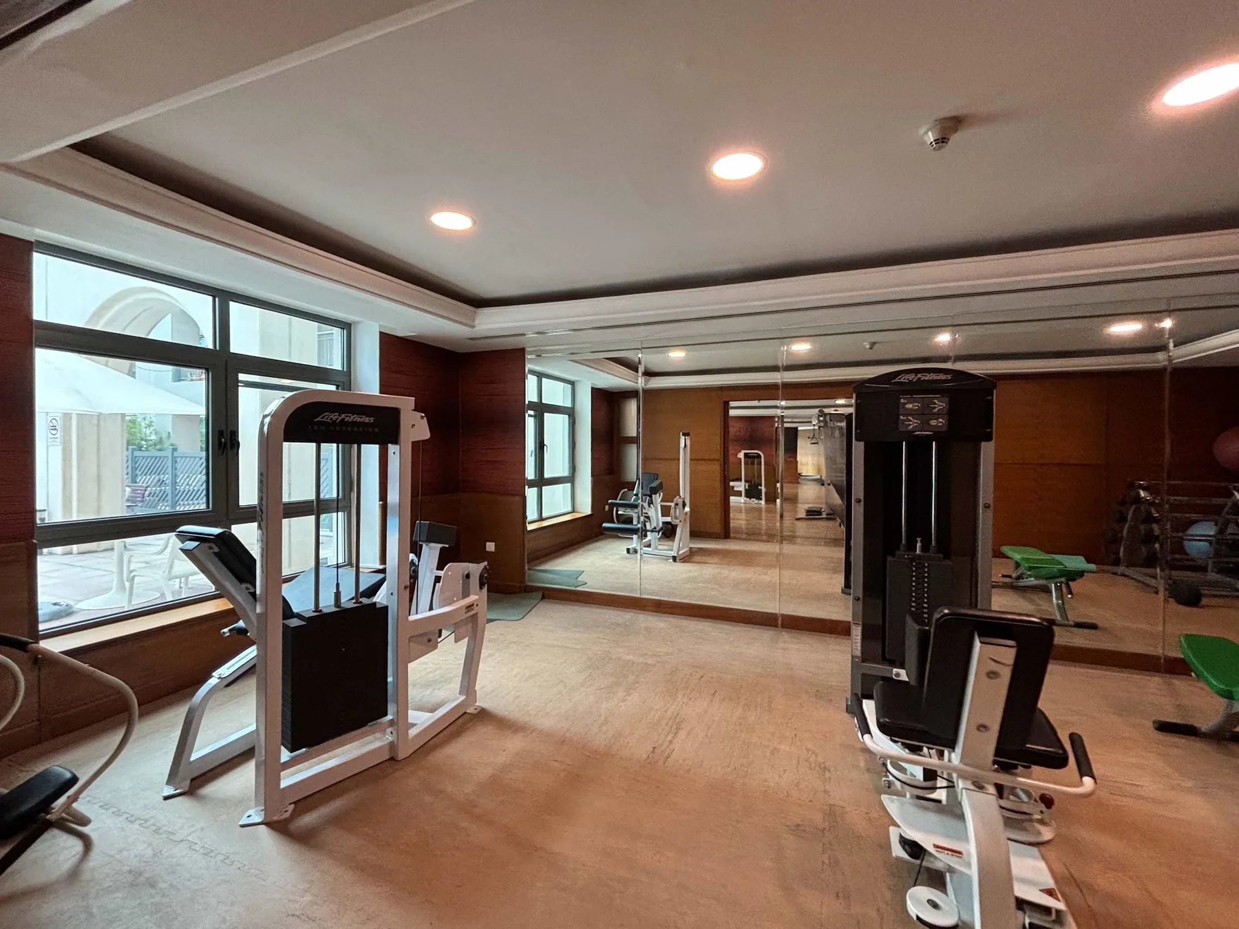 A gym with exercise machines and a mirrored wall.