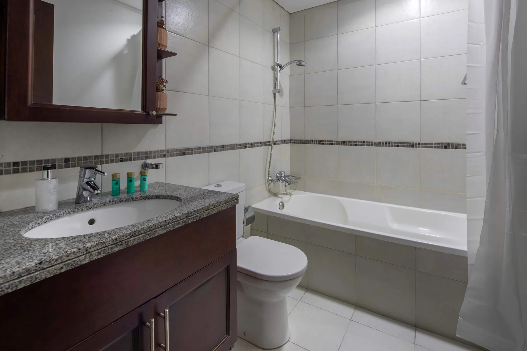 A tiled bathroom with a bathtub, shower, and sink vanity.