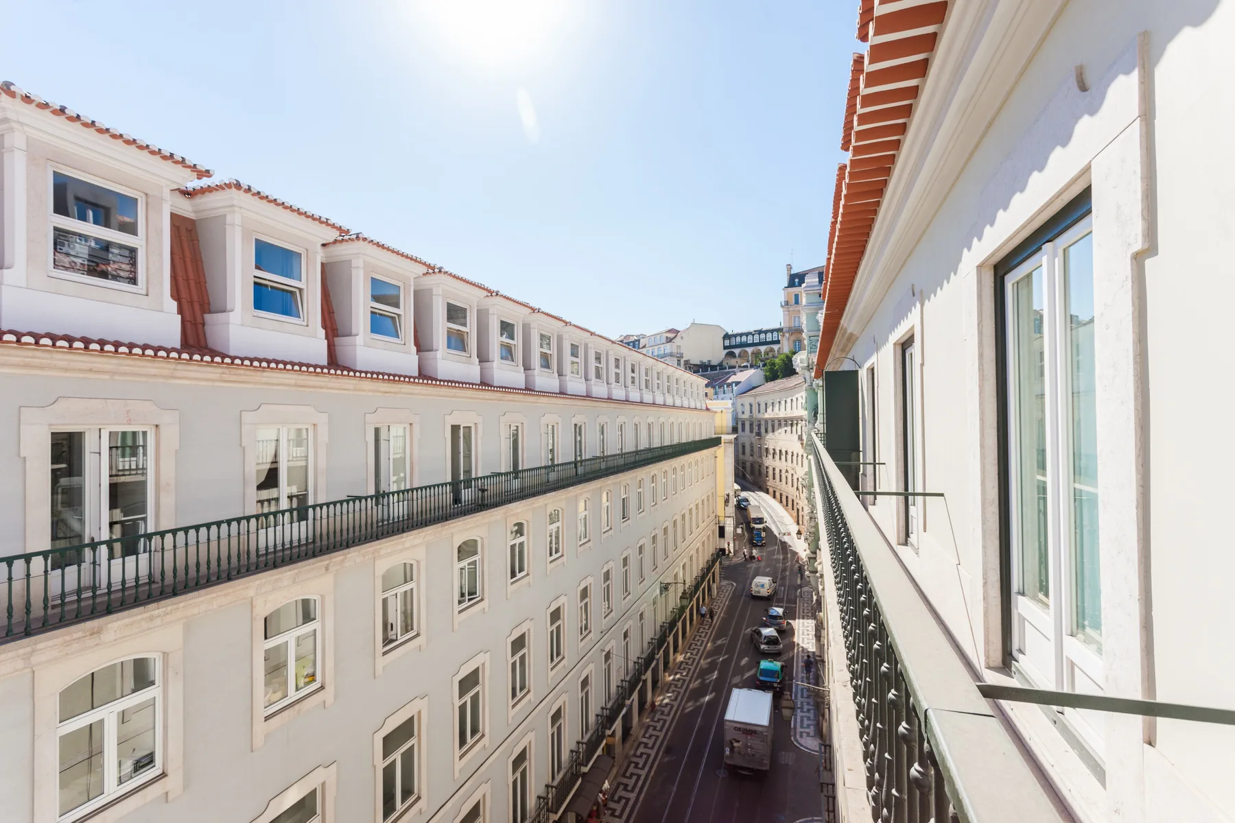Una calle estrecha discurre entre hileras de edificios claros.