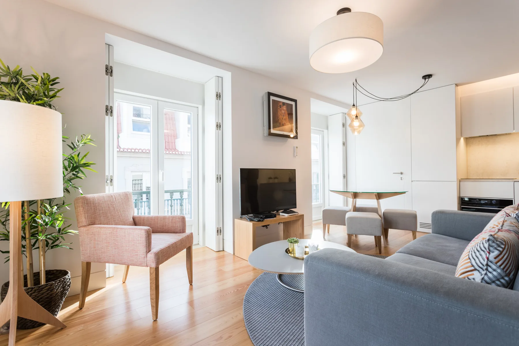 Una sala luminosa con asientos, un televisor y un comedor contiguo.