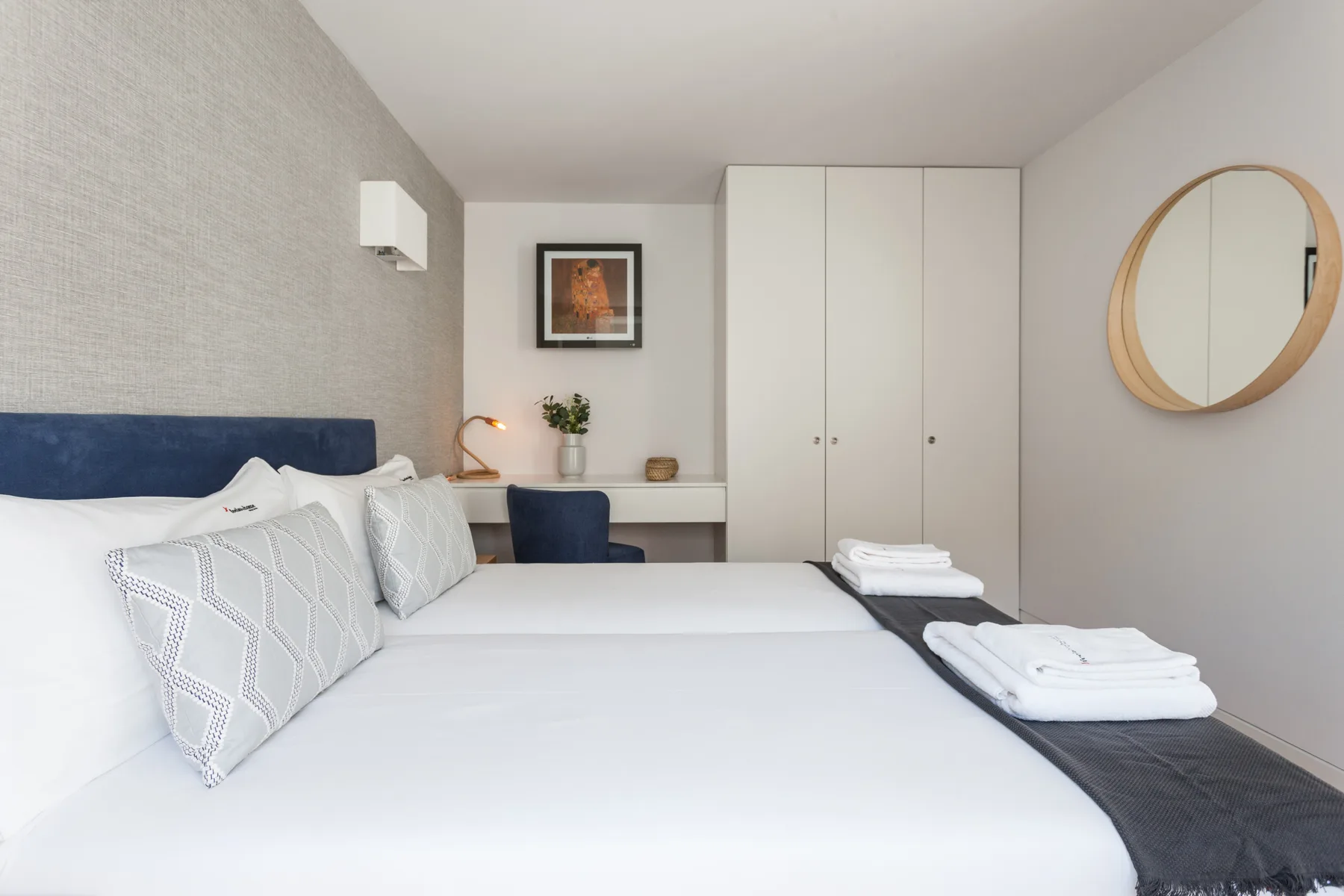 Un dormitorio con una cama bien hecha y armarios empotrados.