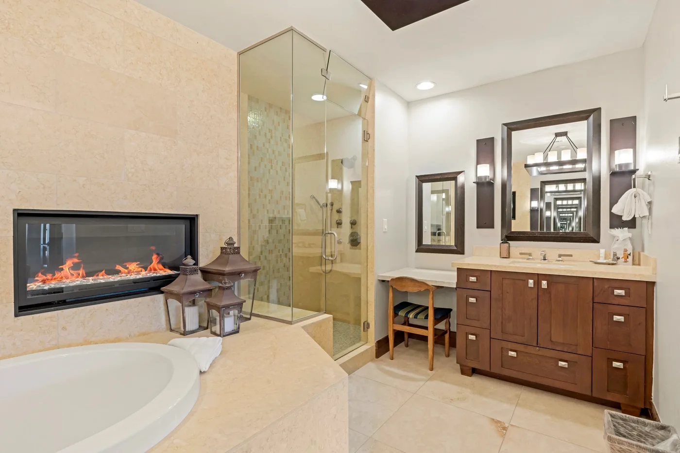 Un baño con ducha de vidrio, tocador y chimenea empotrada.