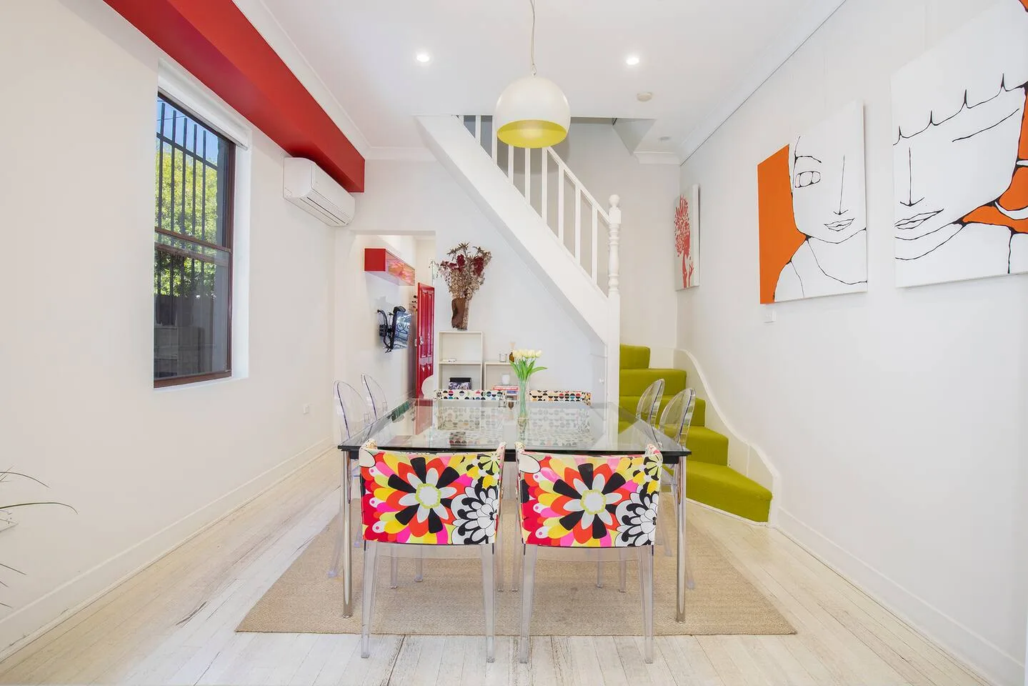 The quirky dining room offers an eight-seater glass table under a funky pendant light.