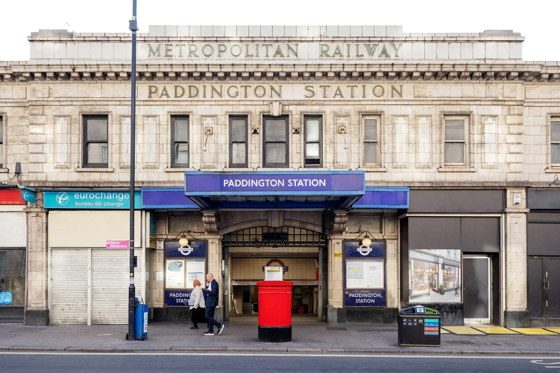 La fachada de piedra de la estación Paddington tiene una entrada central bajo letreros ferroviarios.