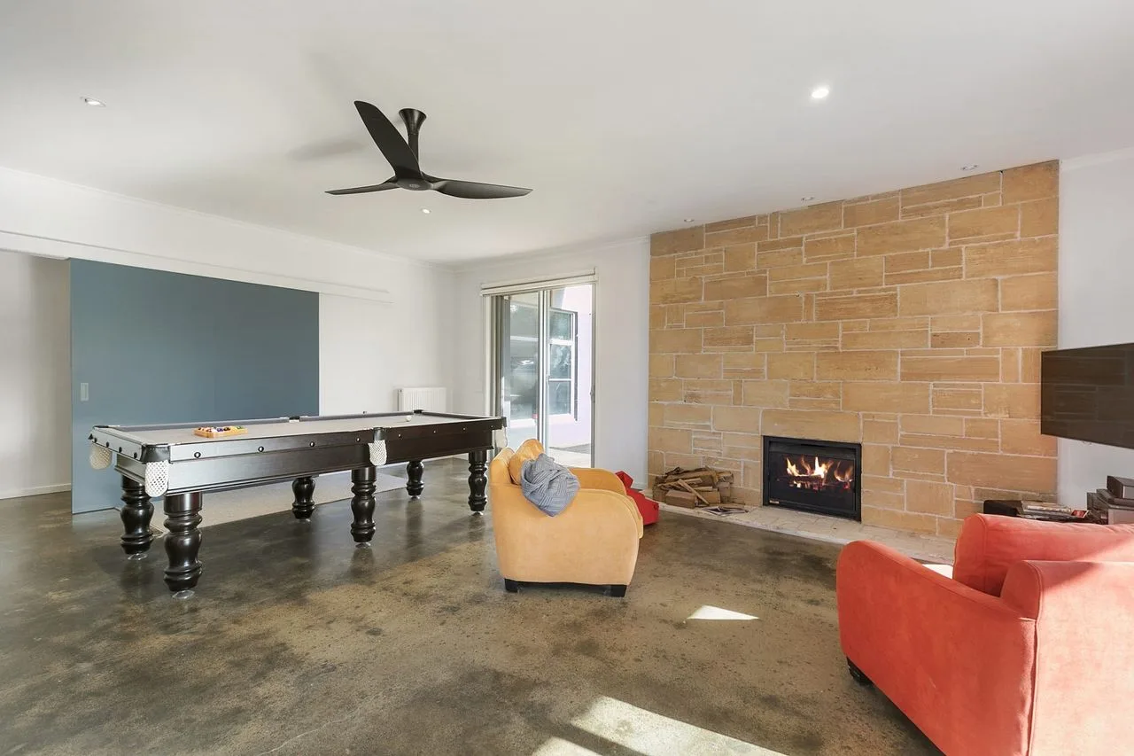 Una sala de estar con mesa de billar, asientos y chimenea.
