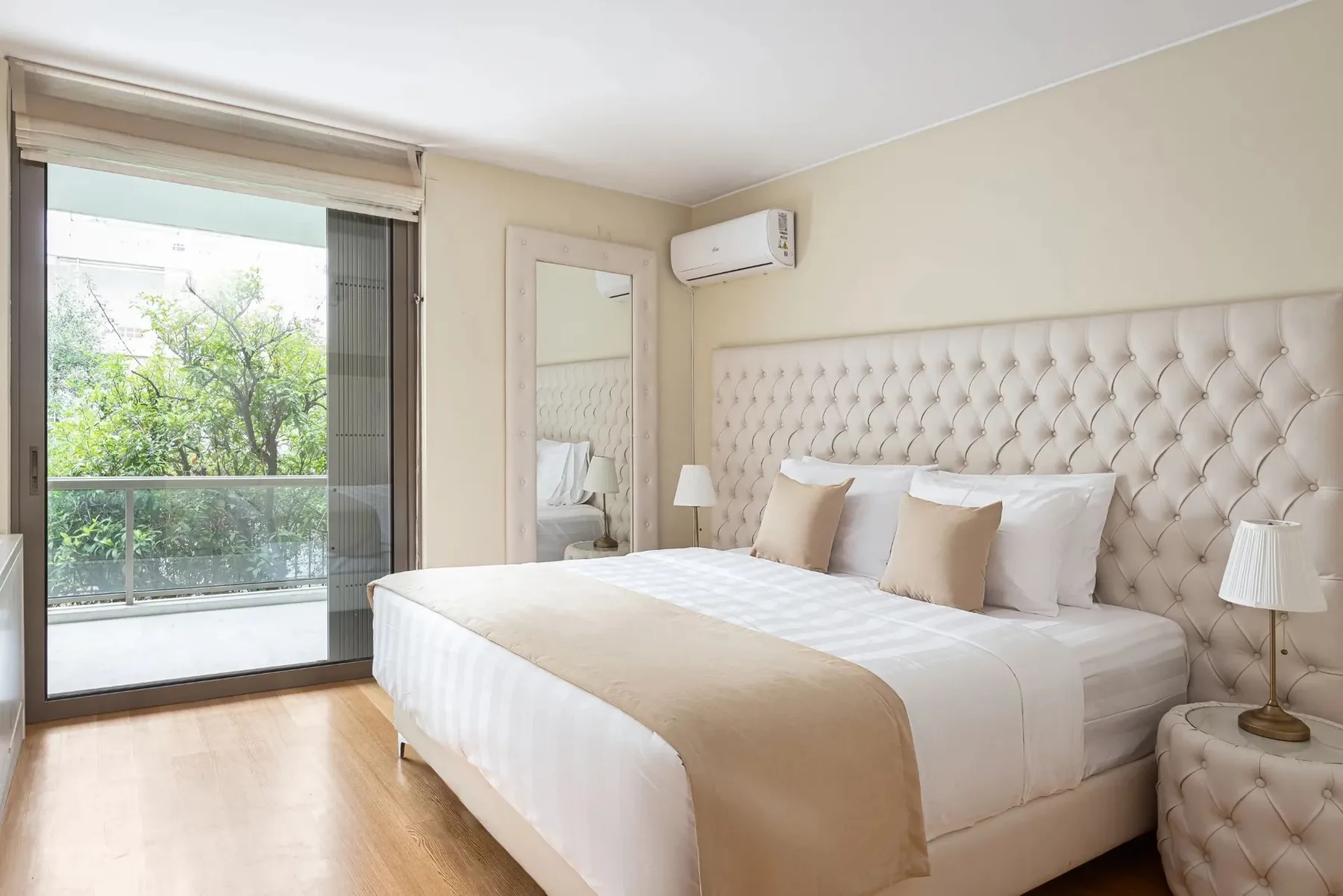 A bedroom with a large bed and sliding glass doors opening to a balcony.