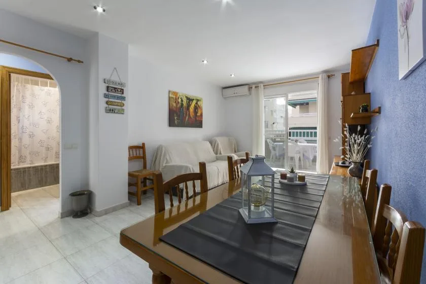 A dining and living room with a long table and seating beside the windows.