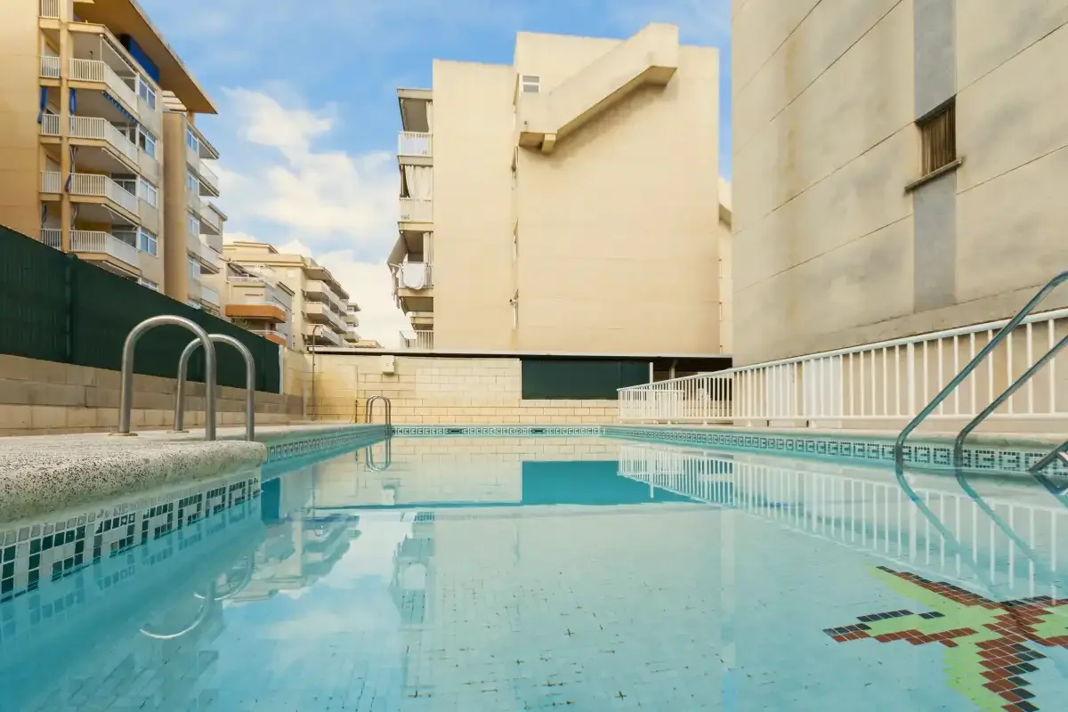 Una piscina al aire libre está entre edificios de apartamentos.