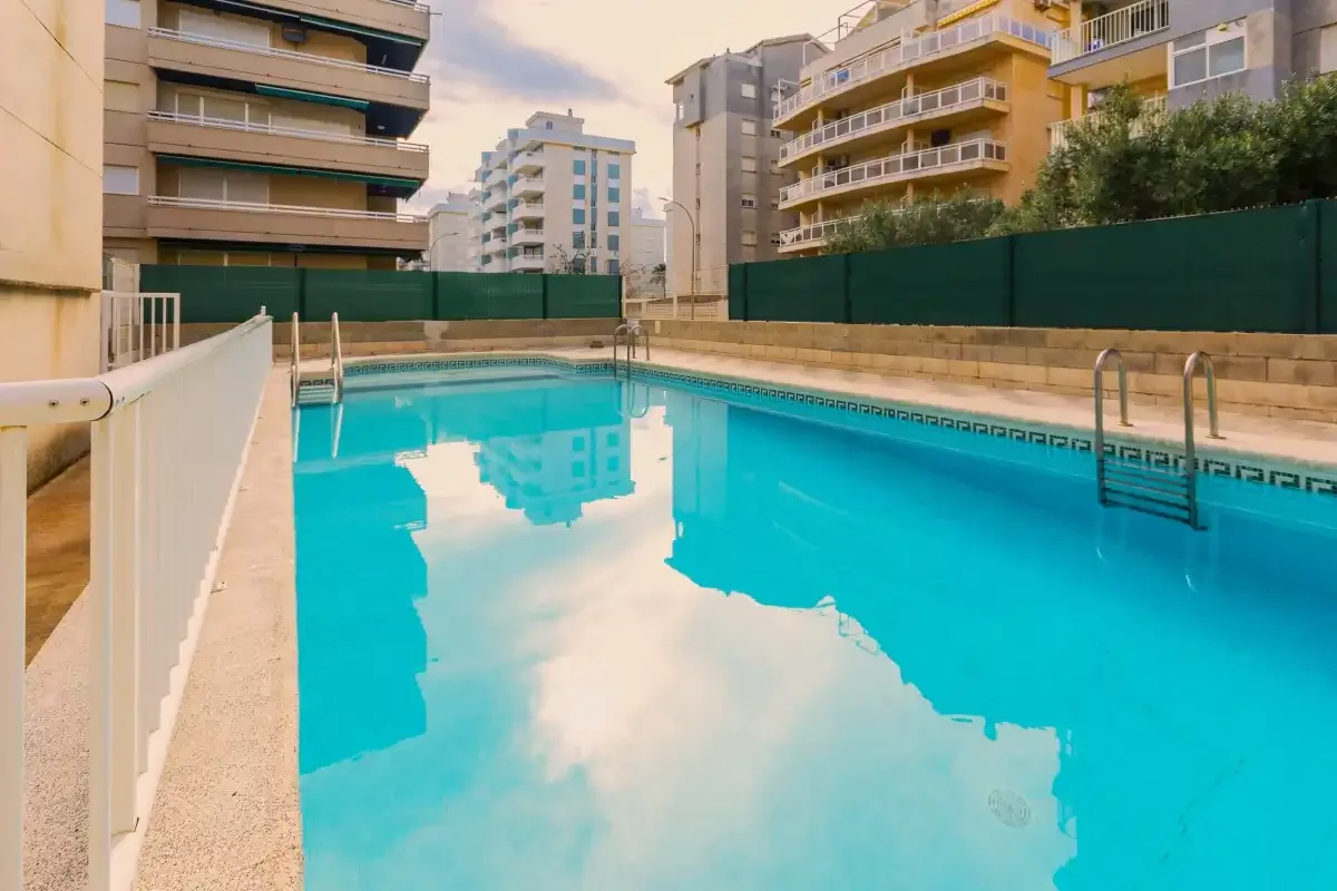 Una piscina al aire libre está rodeada de edificios de apartamentos.