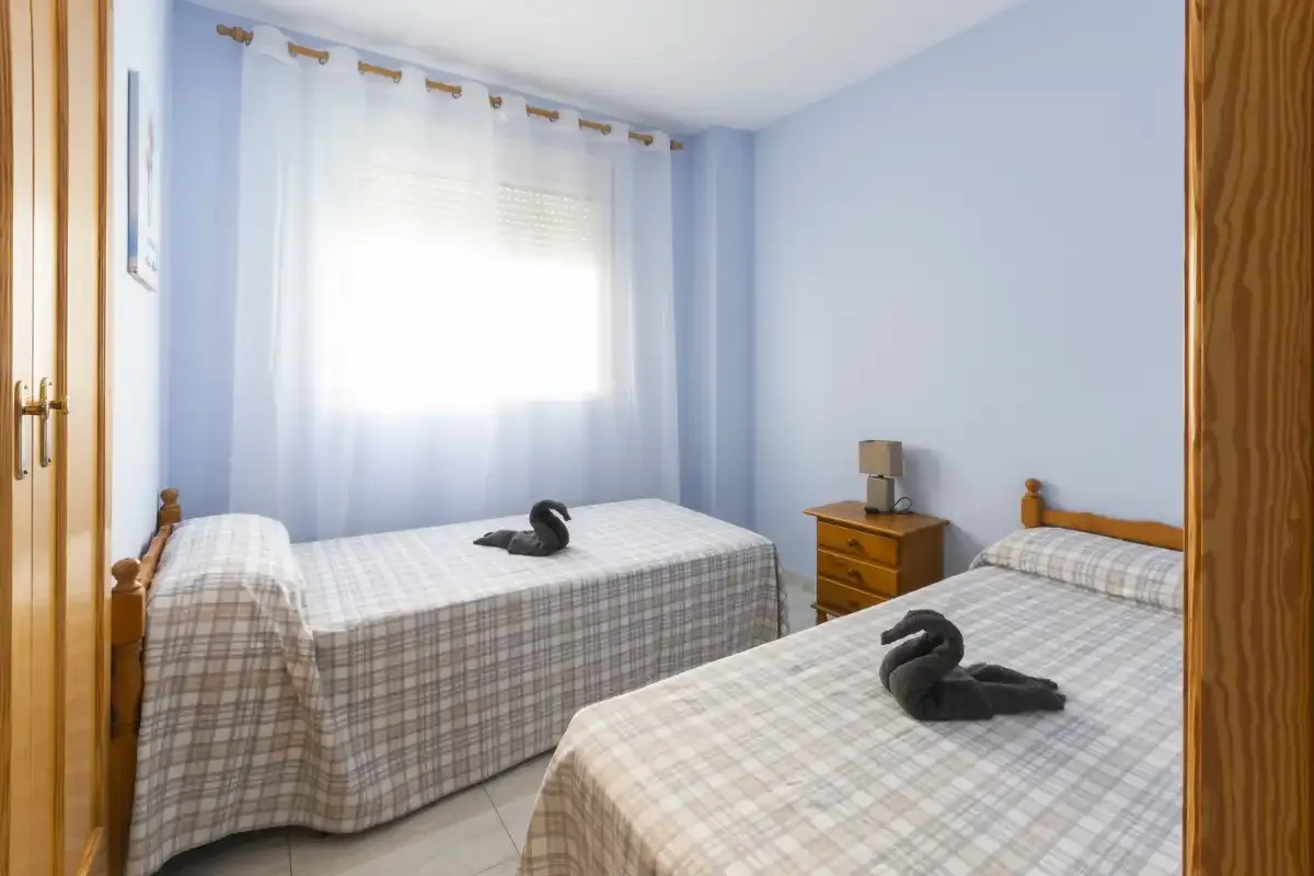 Un dormitorio con dos camas y adornos oscuros con forma de ave.