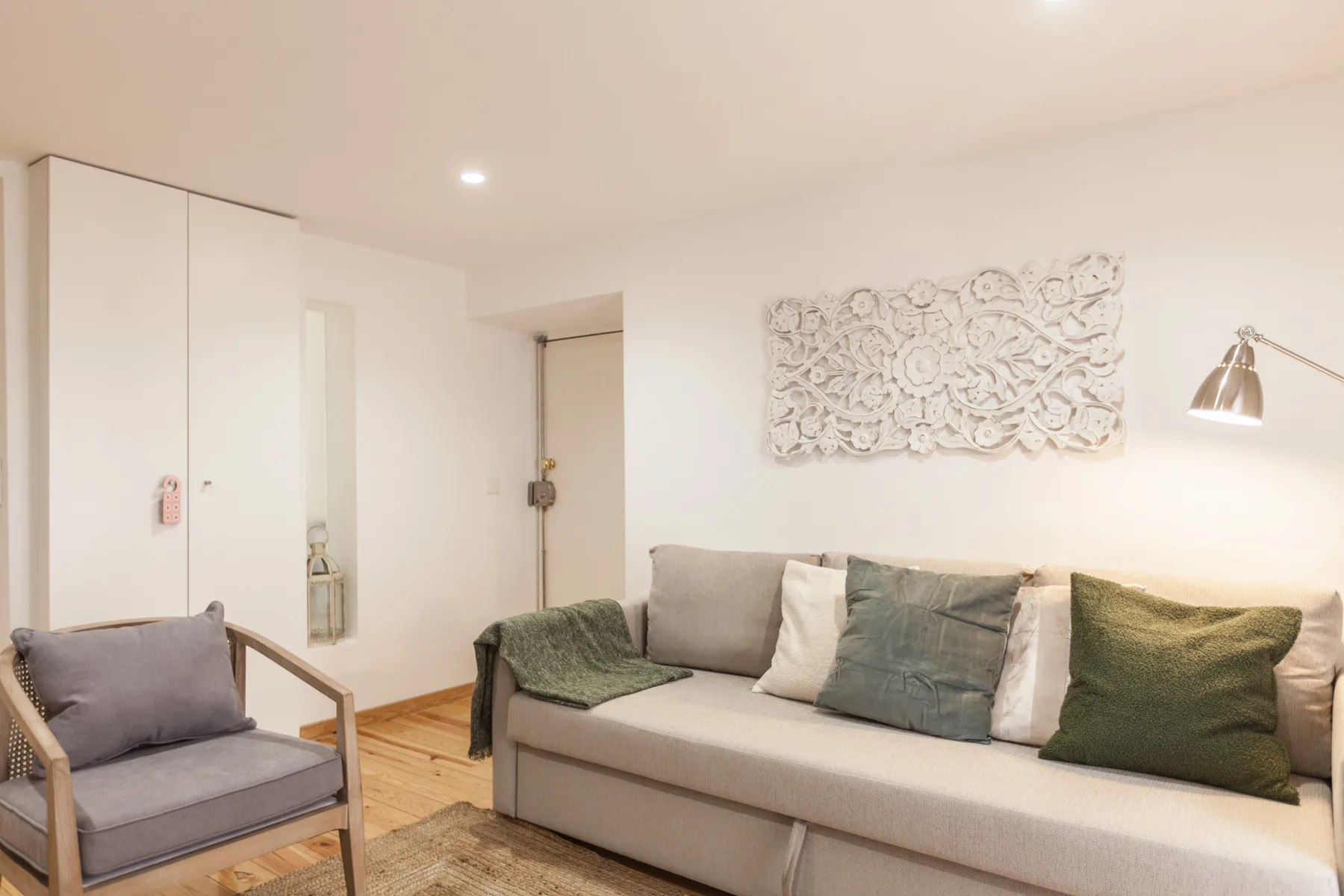 A living room with a sofa, armchair, and decorative wall art.