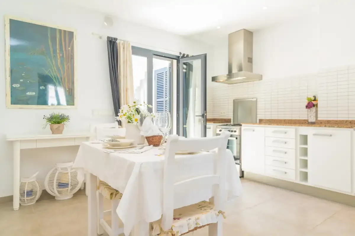 Una cocina luminosa con una mesa puesta junto a la encimera.