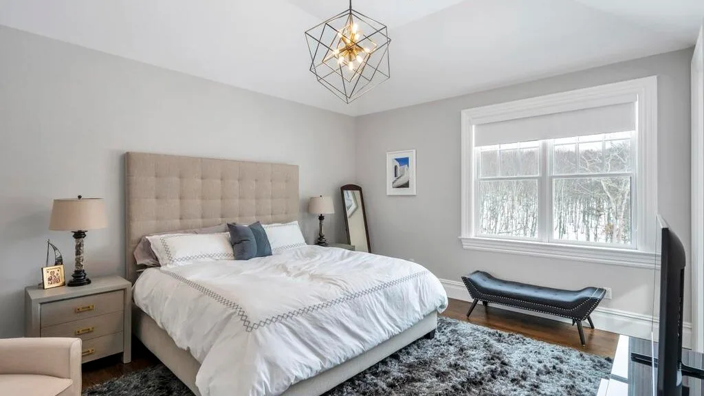 Un dormitorio luminoso con una cama grande y una ventana amplia.