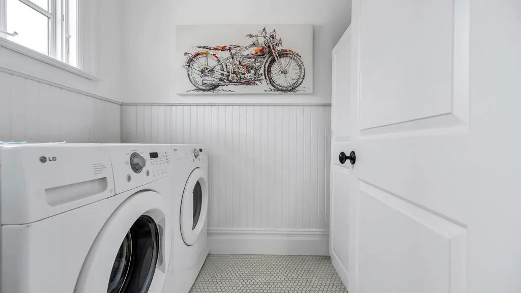 Un cuarto de lavandería con lavadora y secadora bajo una imagen de una bicicleta.