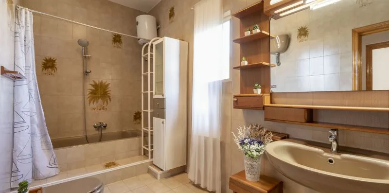 Un baño luminoso con bañera, lavabo y ducha.
