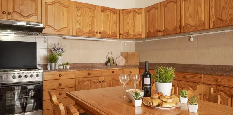 Una cocina con gabinetes de madera, una estufa y una mesa puesta con comida.