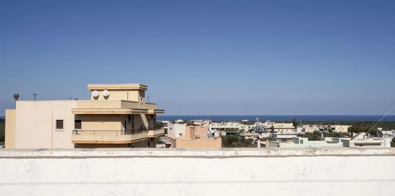 Se ven edificios bajos de una localidad costera bajo un cielo despejado.