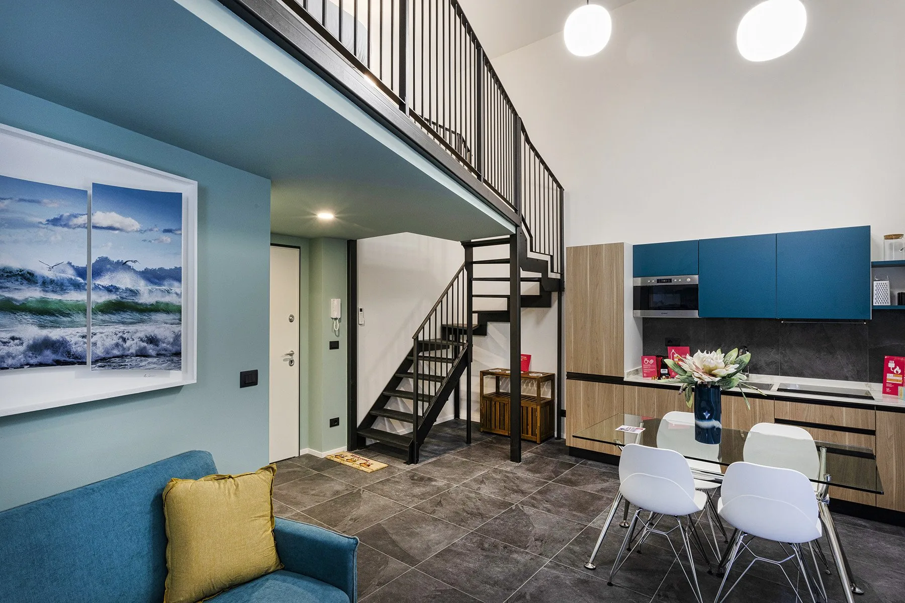 Un espacio abierto de sala y comedor con una escalera y cocina.