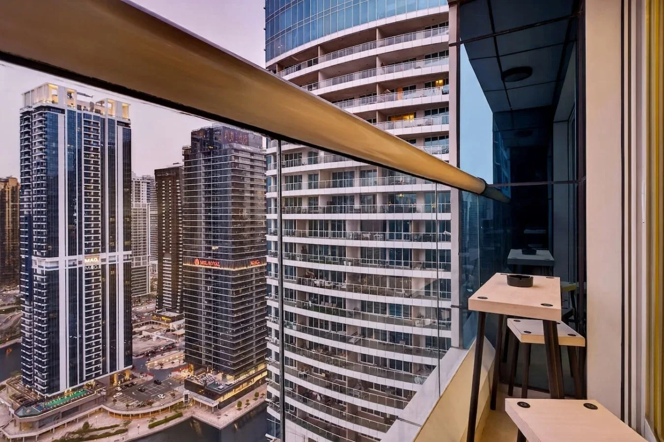 Panorámica urbana de edificios altos vista desde un balcón con barandilla.