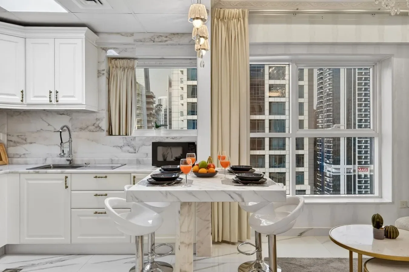 Una cocina y comedor luminosos con una mesa junto a grandes ventanas.