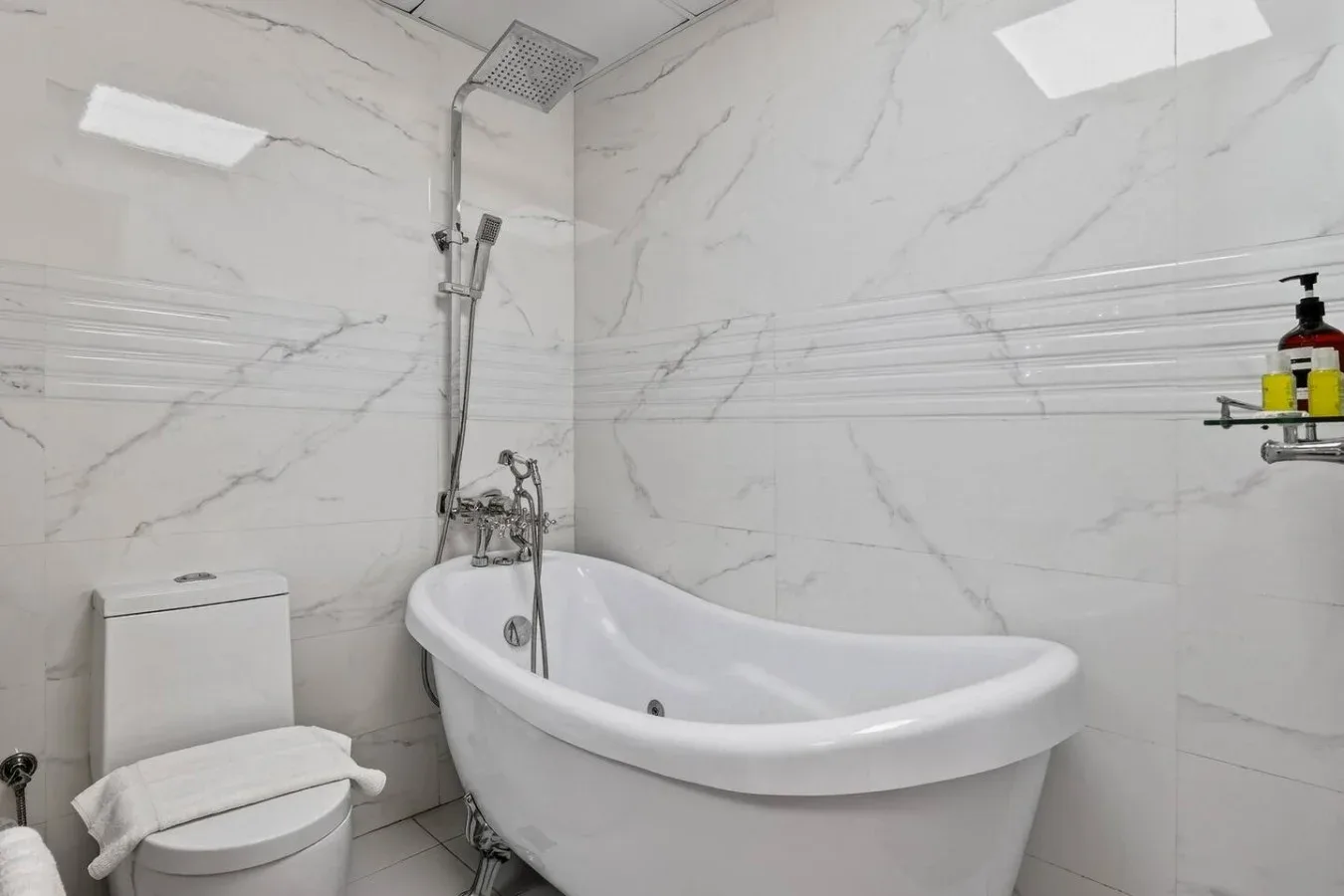 Un baño con bañera, ducha de mano e inodoro.
