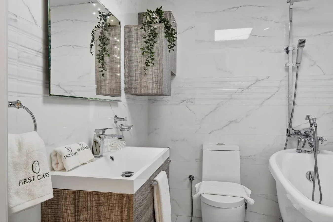 Un baño luminoso con lavabo, inodoro y bañera exenta.