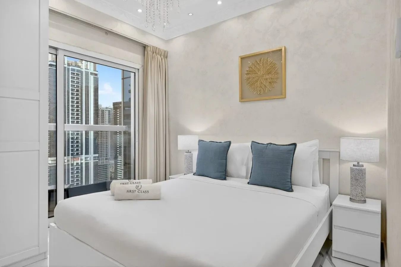 Un dormitorio luminoso con una cama bien arreglada y ventanas grandes.