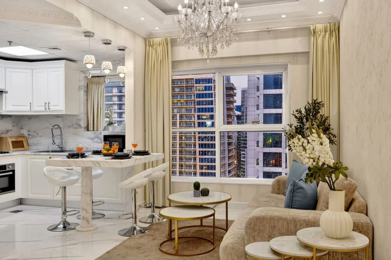 Una luminosa sala de estar con barra de comedor, asientos y grandes ventanas con vista a edificios cercanos.