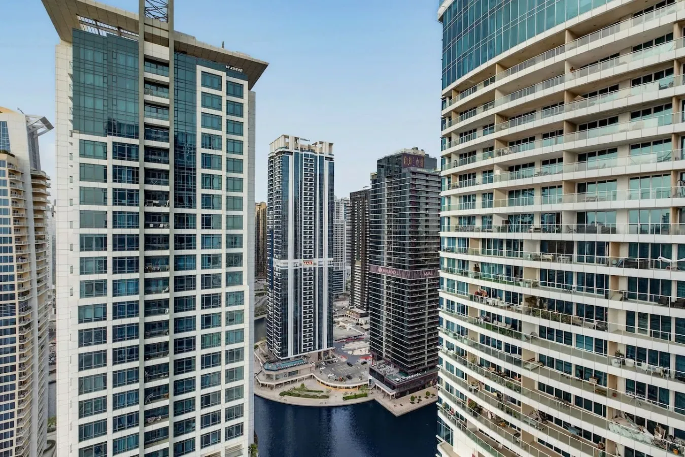 Un conjunto de edificios modernos de gran altura rodea un canal en un paisaje urbano.