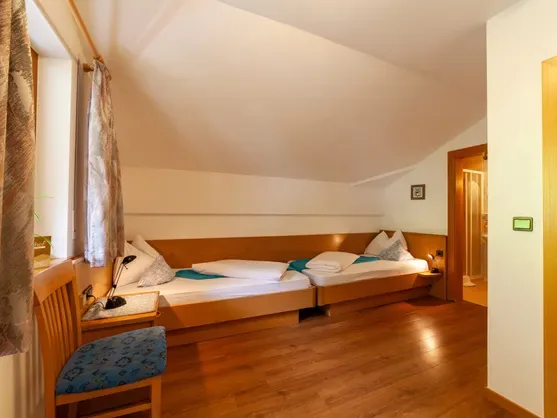 Acogedora habitación de estilo alpino con dos camas de madera y ventana