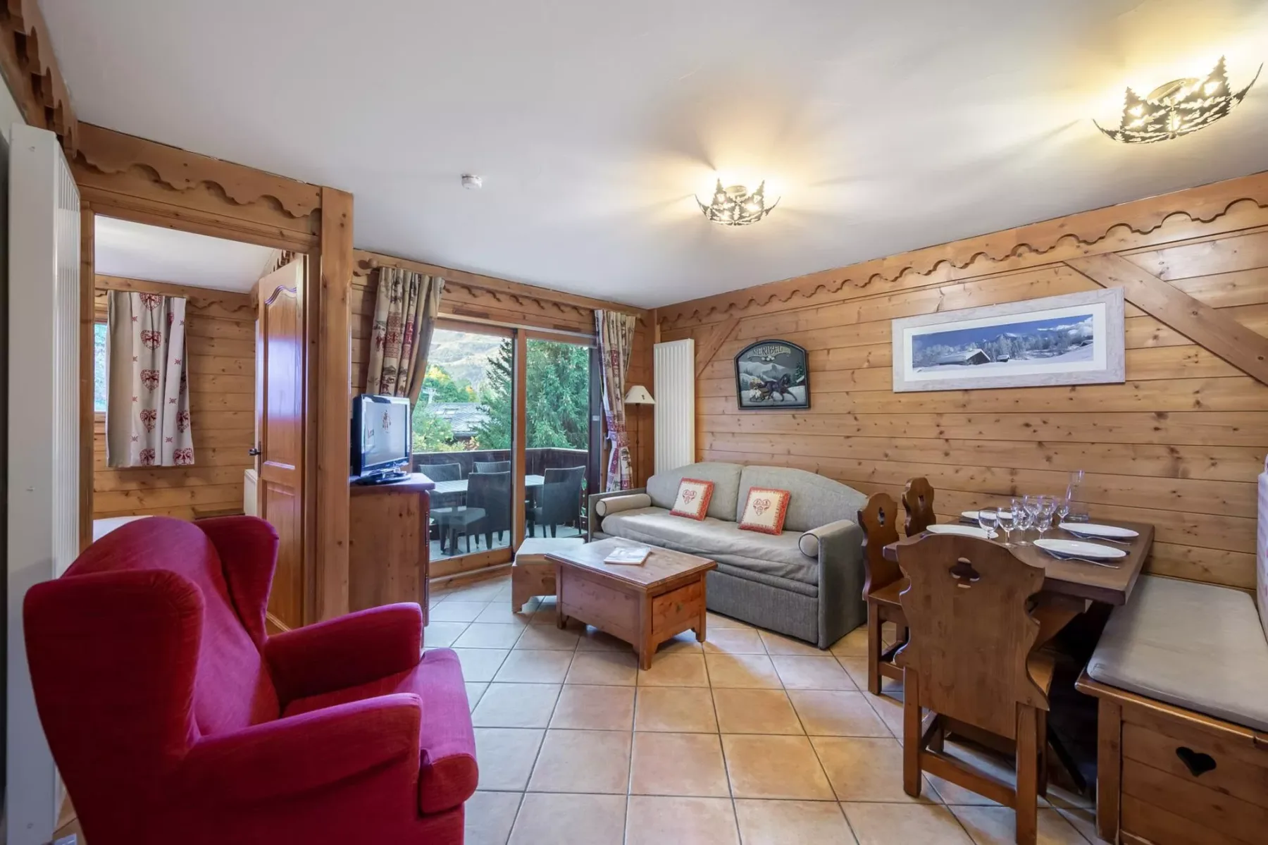 A wood-paneled living and dining area with seating beside a glass door.