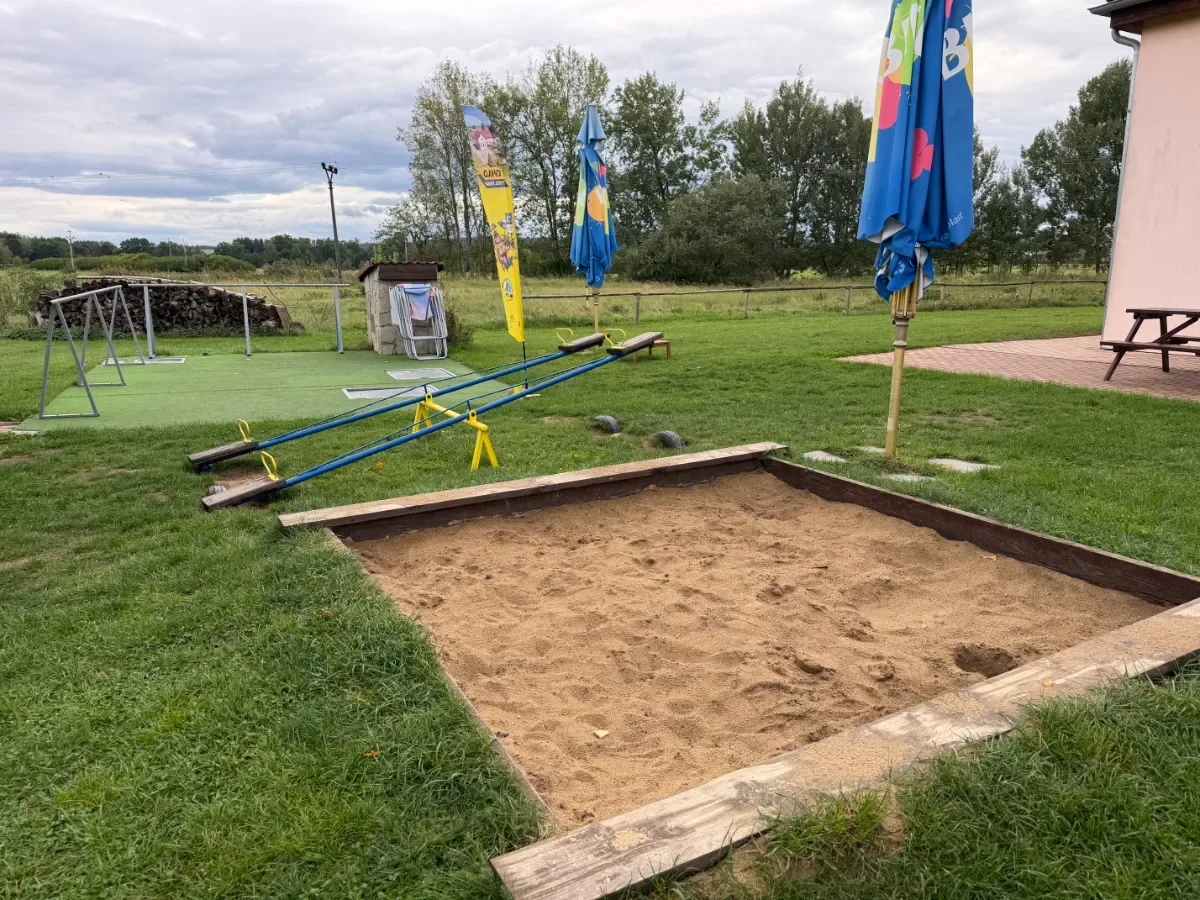 Zona de juegos infantiles con arenero y columpios