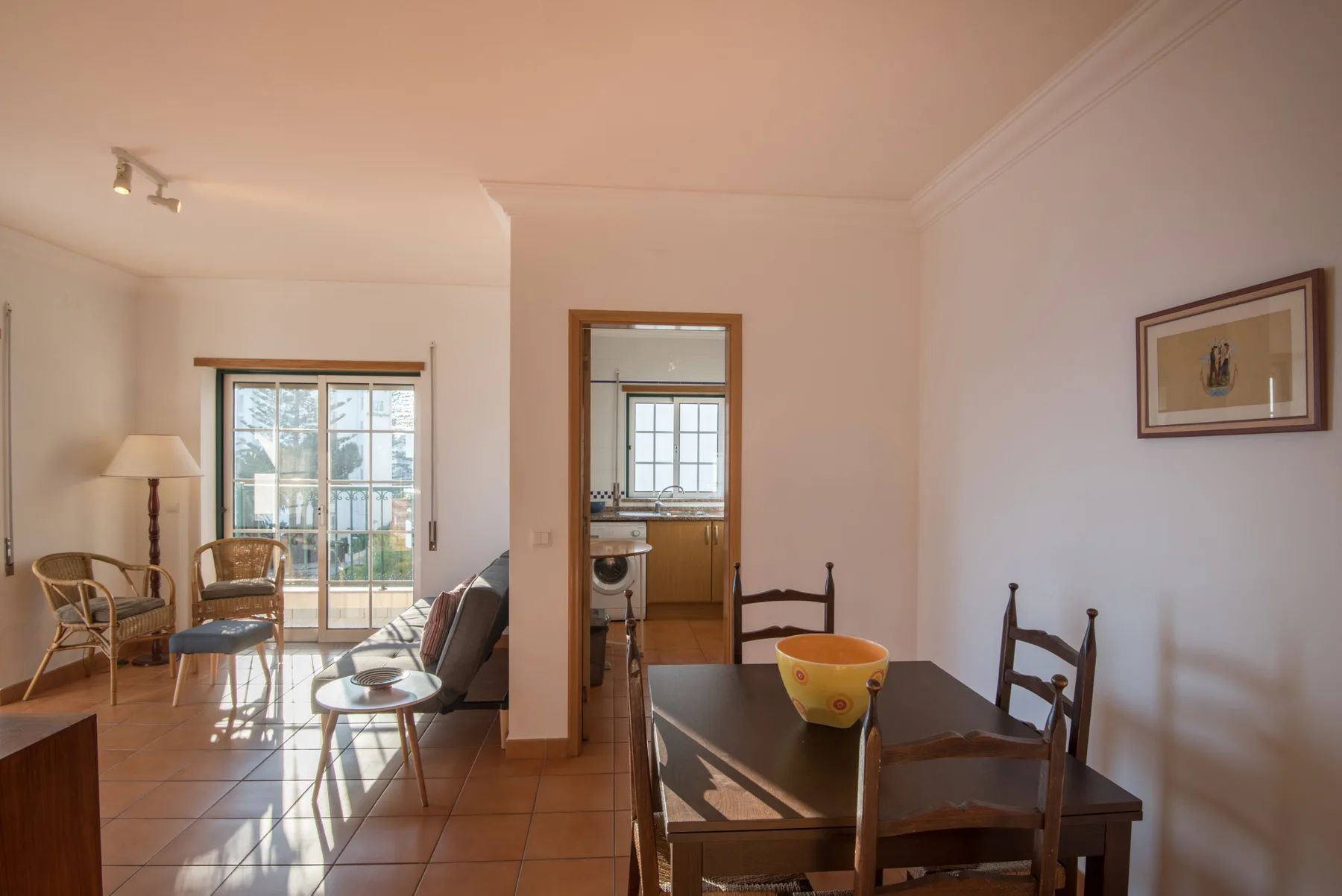 Un comedor con una mesa de madera se abre a una luminosa sala de estar.