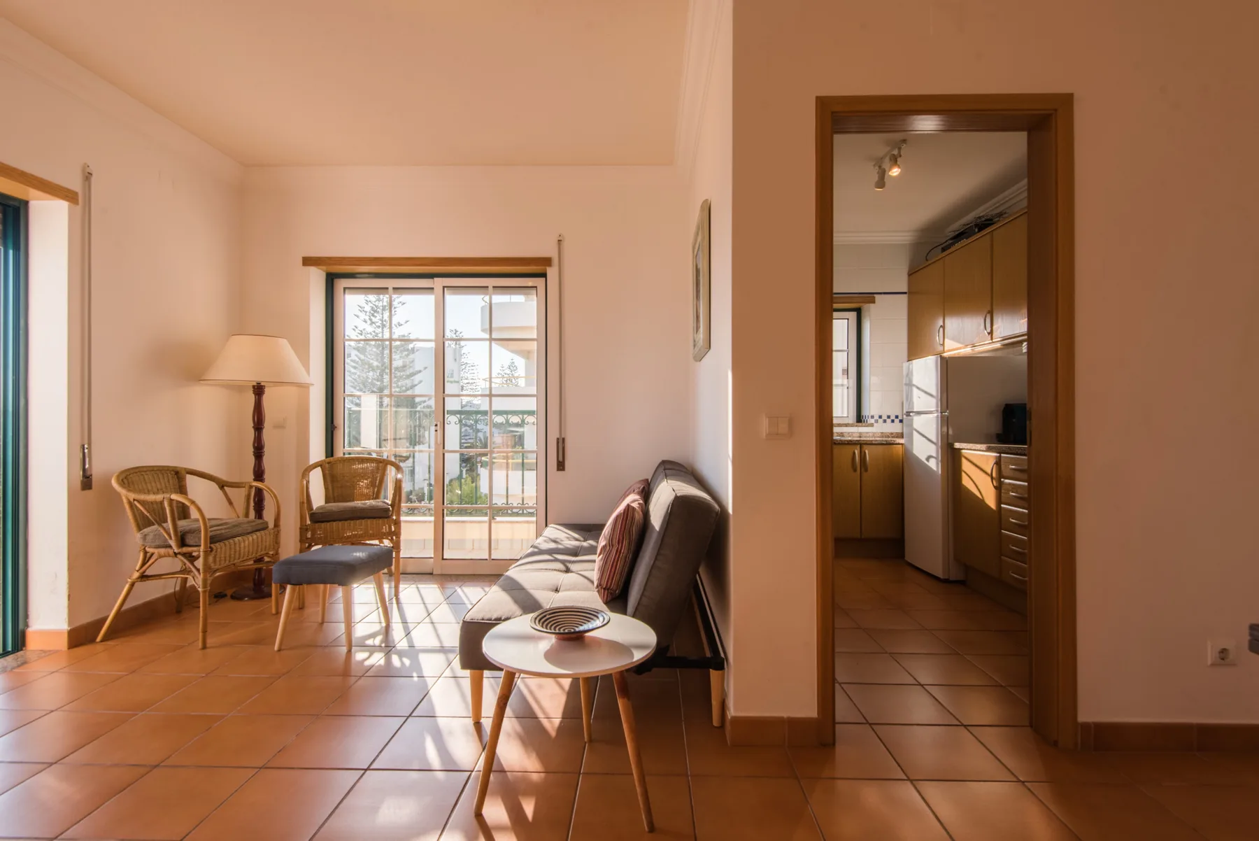Una sala de estar con asientos y una puerta de cristal que da a un balcón.