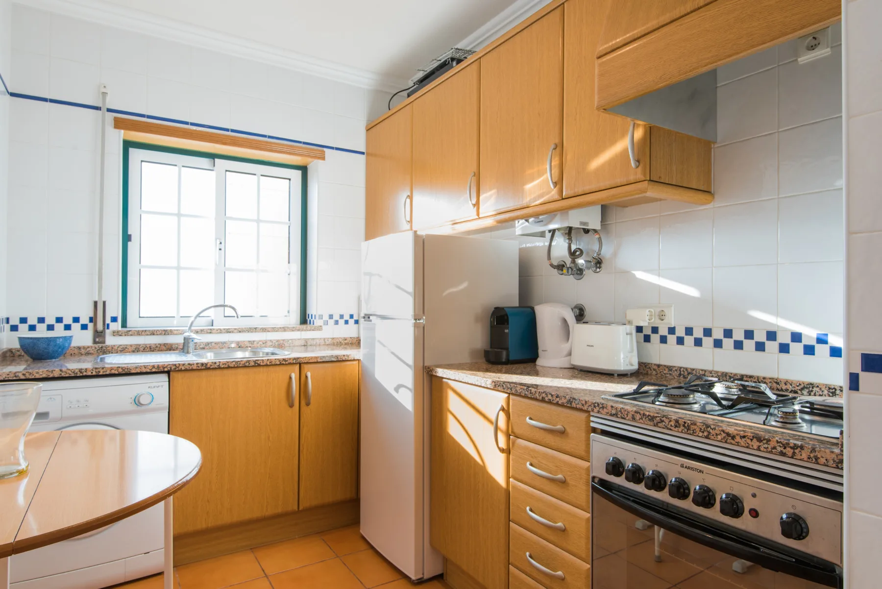 Una cocina luminosa con armarios de madera, una ventana y una encimera.