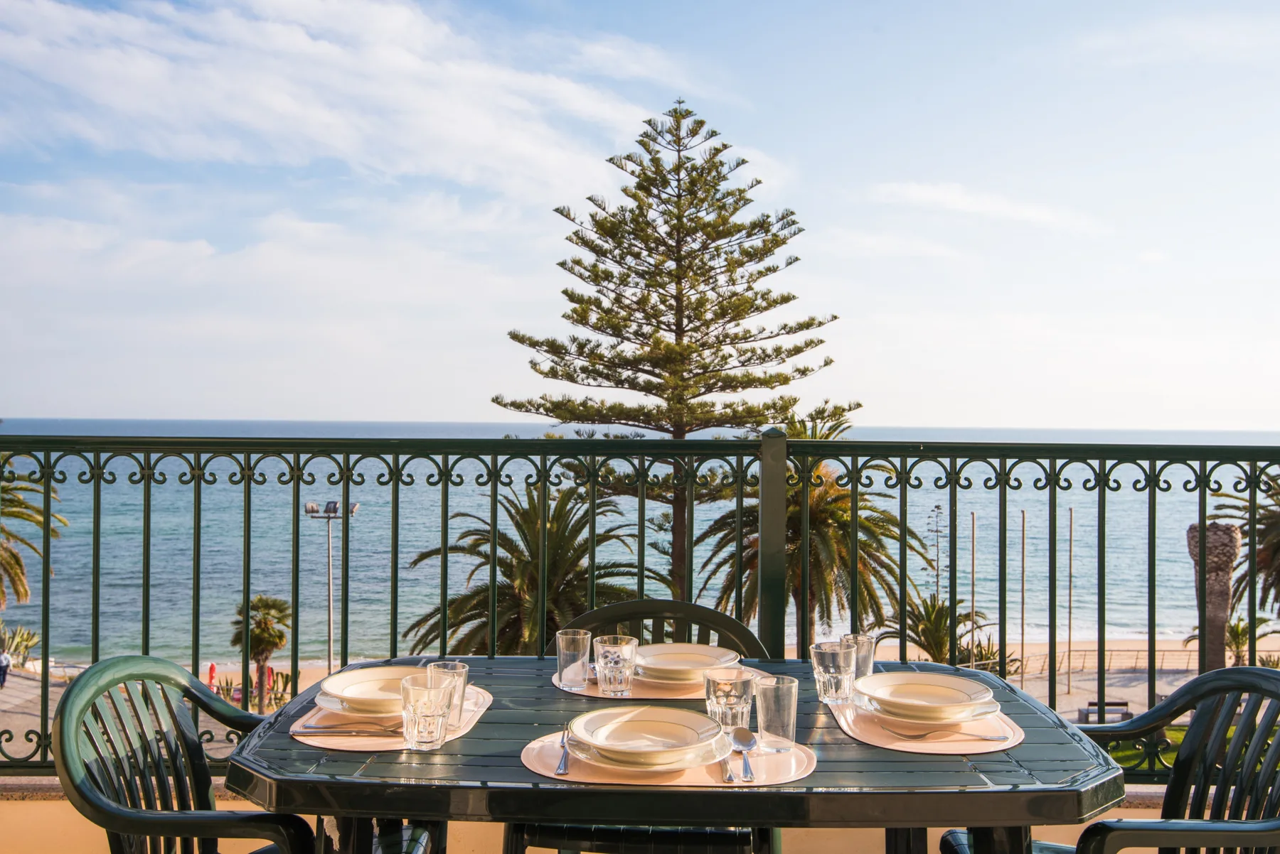Una mesa de comedor en el balcón da a la playa y al mar.