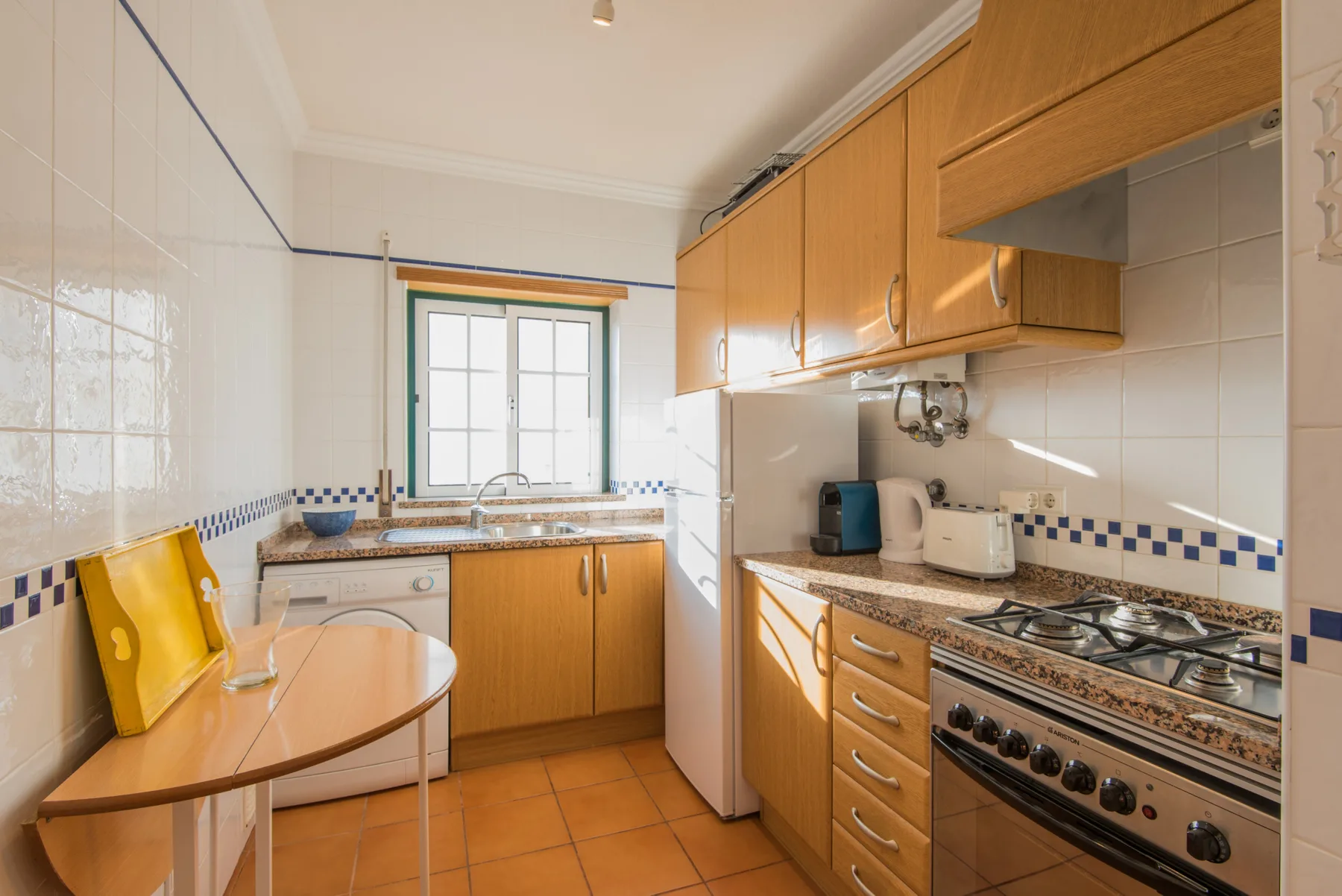 Una cocina alicatada con armarios de madera, una encimera y una estufa.