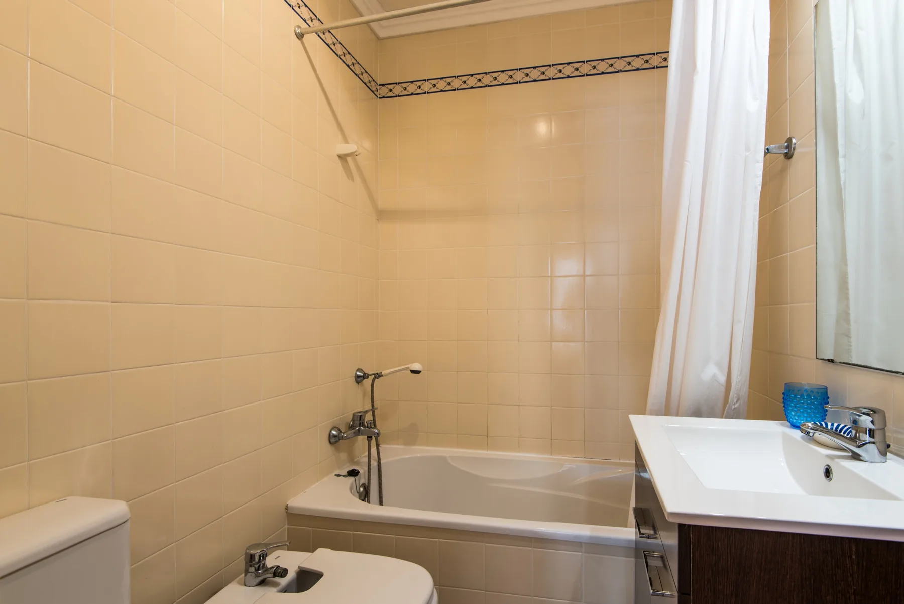 Un baño alicatado con bañera y lavabo.