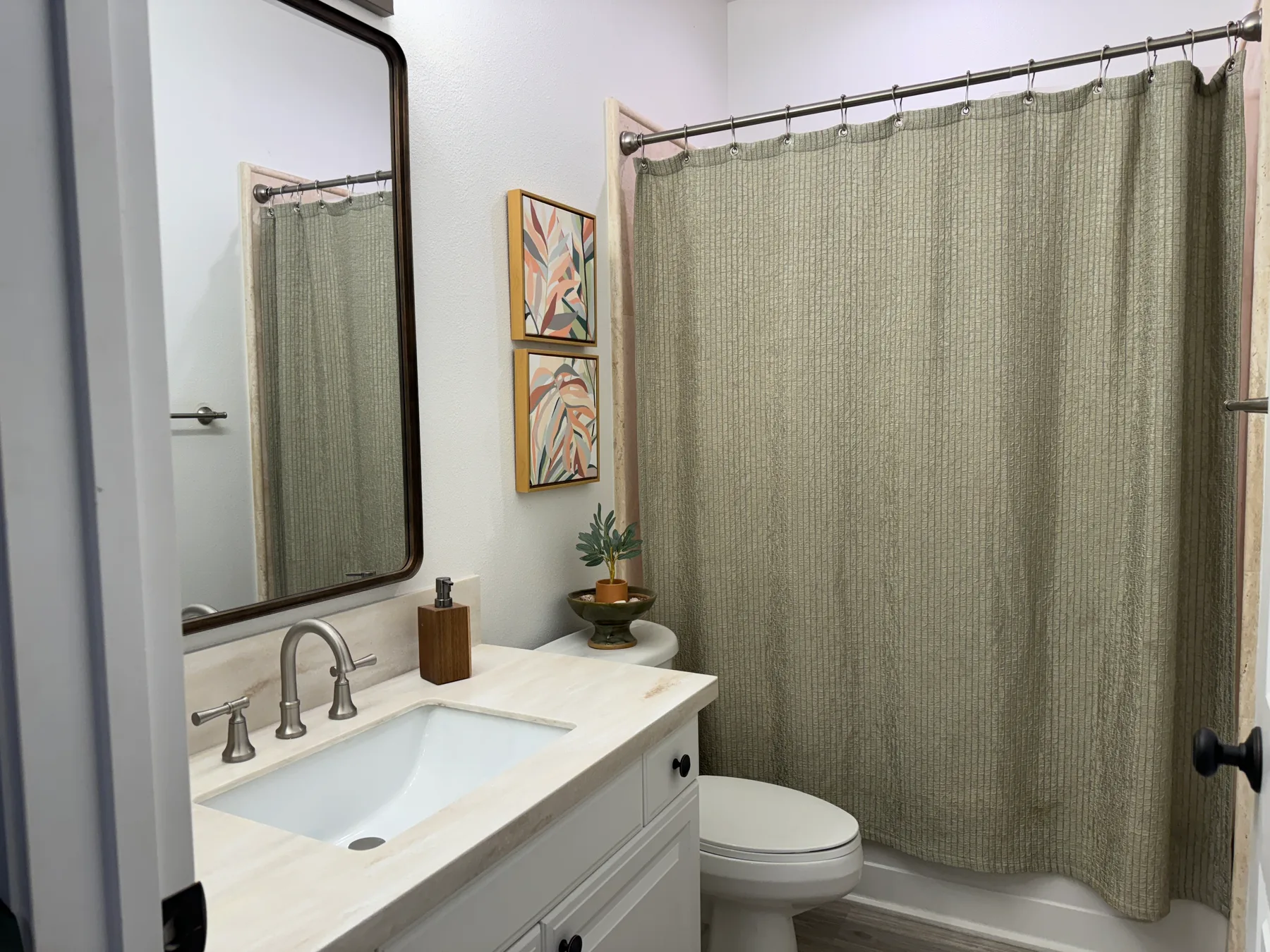 Un baño con lavabo, inodoro y ducha detrás de una cortina.