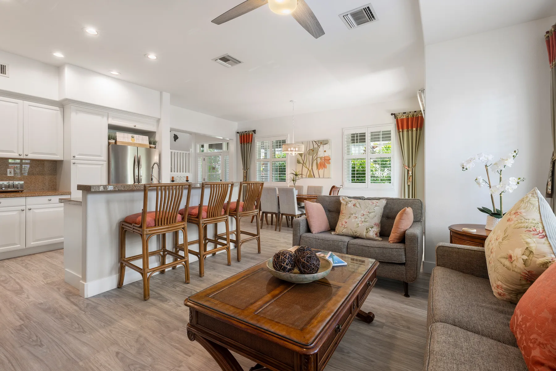 Sala de estar y cocina de planta abierta con una barra y asientos.