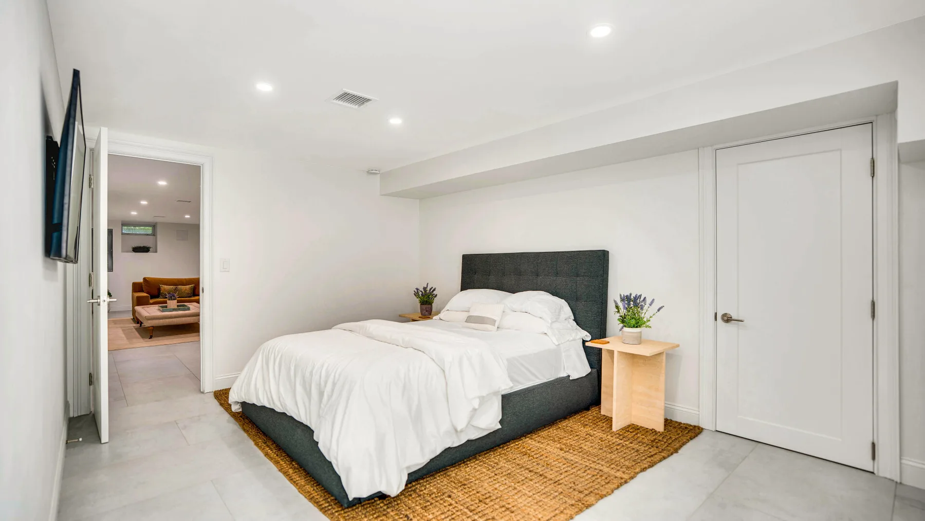 Un dormitorio luminoso con una cama grande y ropa de cama blanca.