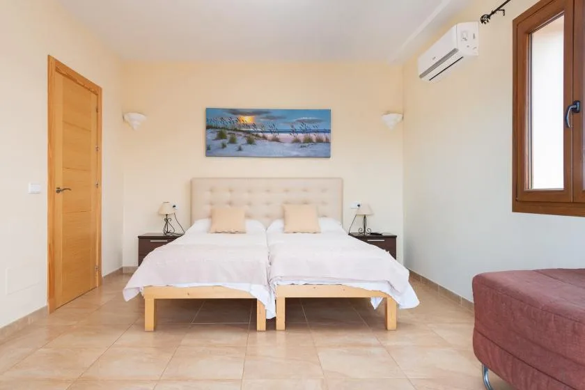 Un dormitorio con dos camas bajo un cuadro panorámico.