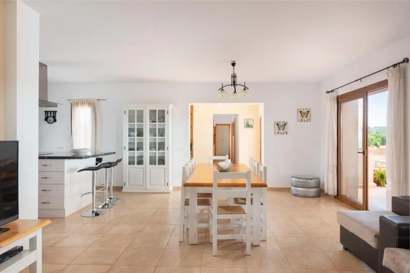 Un comedor diáfano y luminoso, con una mesa junto a la cocina y puertas corredizas de vidrio.