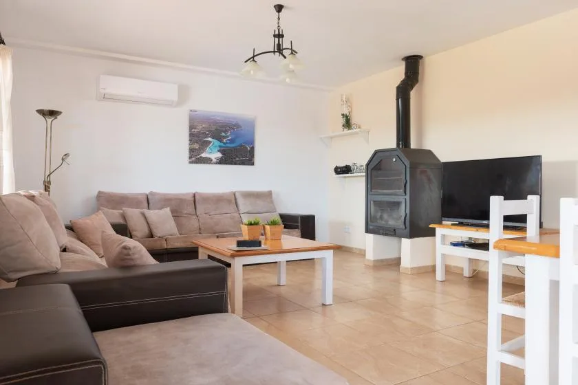 Una sala luminosa con asientos, una mesa de centro y una chimenea independiente.