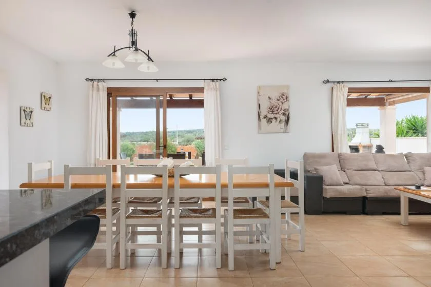 Un luminoso comedor y sala de estar con una mesa larga y asientos.