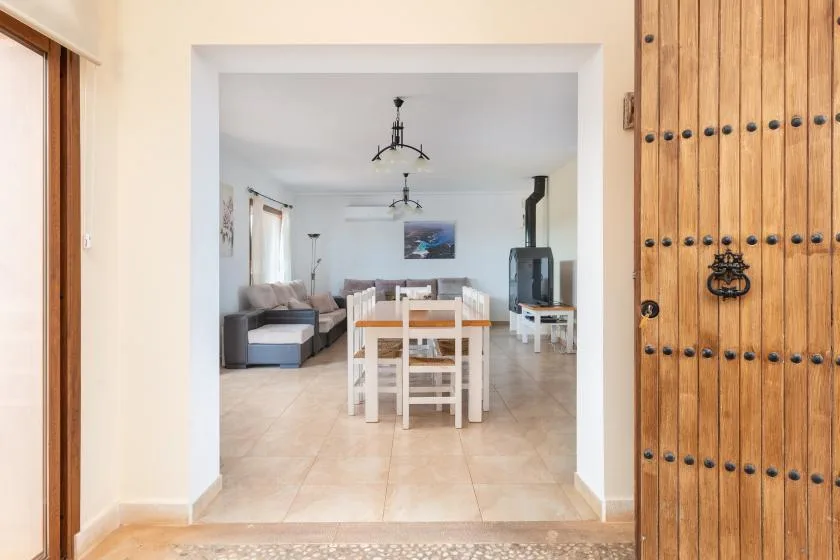 Un comedor se abre a una sala de estar con asientos y un televisor.