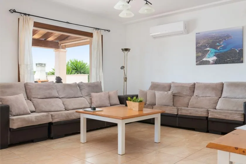 Una sala luminosa con asientos seccionales y una mesa de centro de madera.