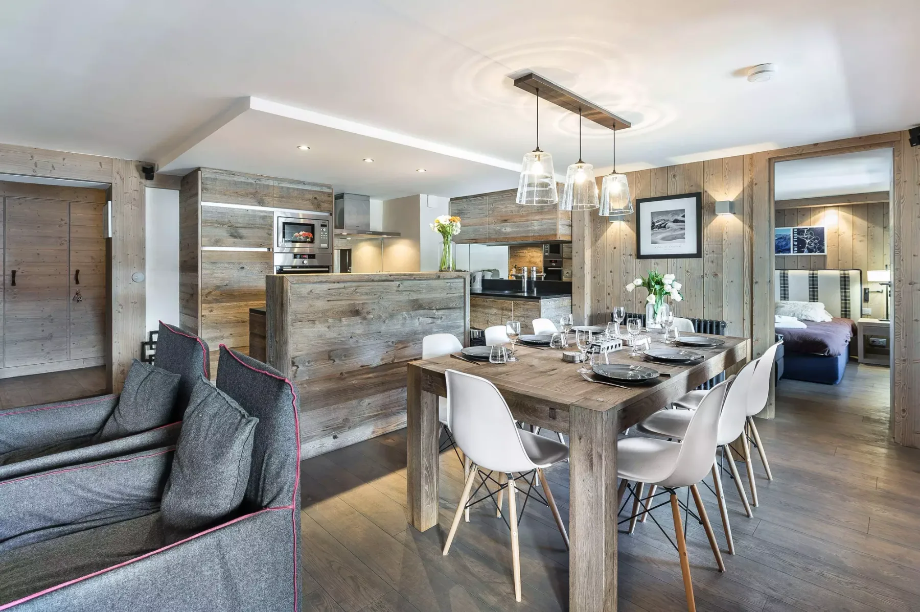 An open-plan living and dining area features a dining table beside the kitchen.