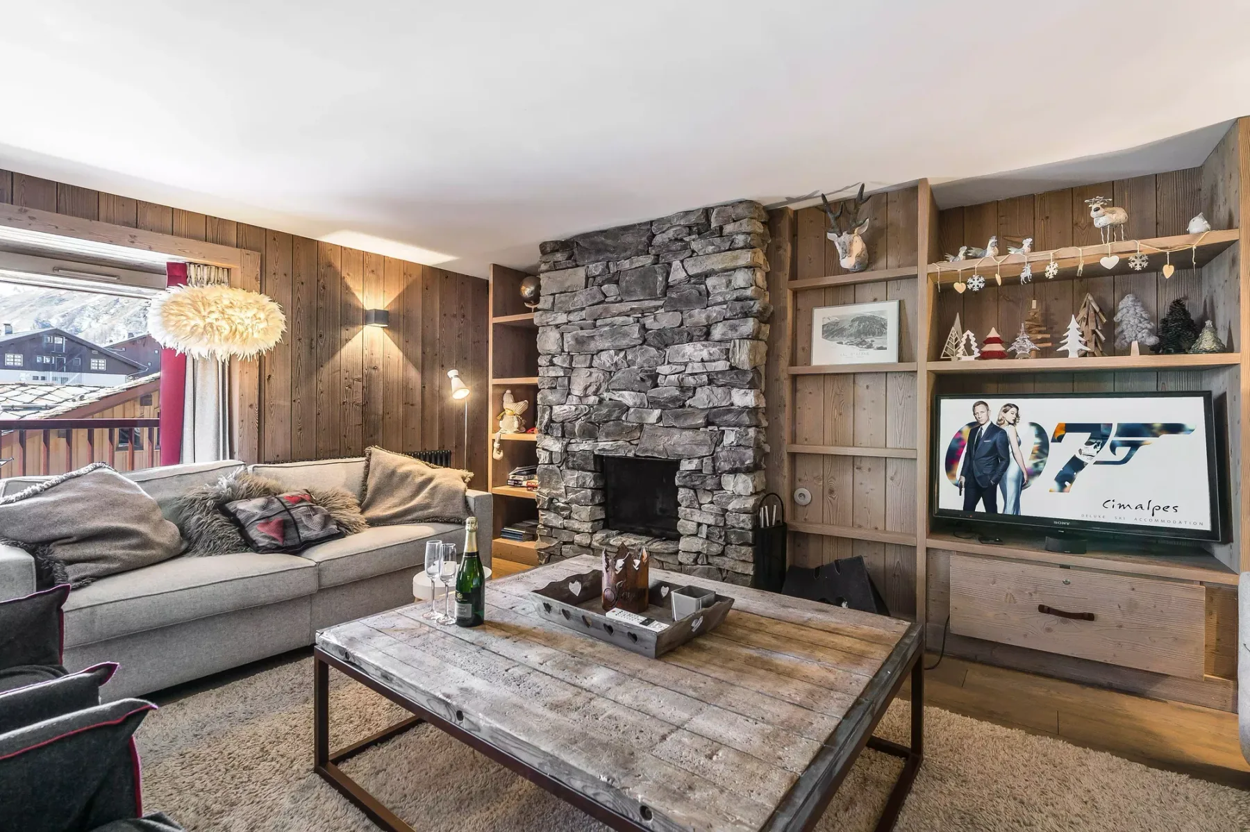 Una sala rústica con chimenea de piedra, asientos y una mesa de centro de madera.